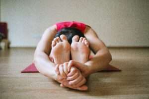 Lady stretching forward and touching her toes