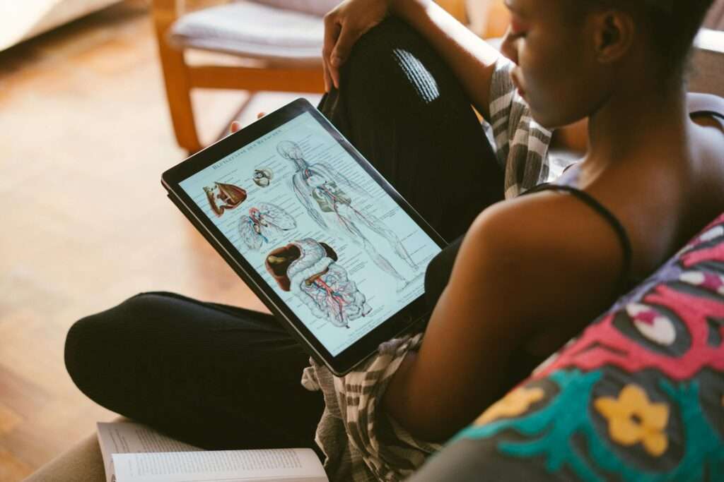 Woman Studying Anatomy, she be studying to become a Registered Massage Therapist.