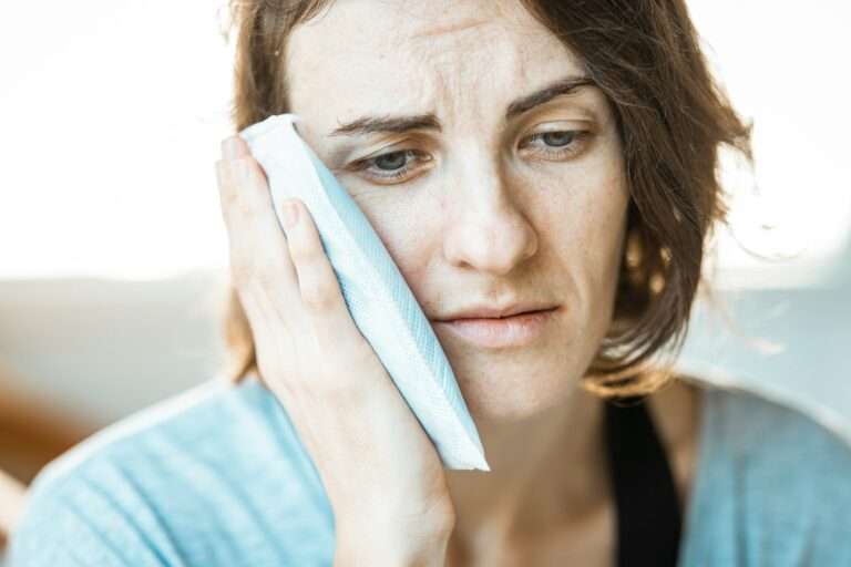 Pain Relief and Performance are things that Massage Therapy can help with, like this woman holding her jaw in pain.